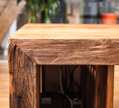 Nahaufnahme einer massiven Tischkante aus Altholz.