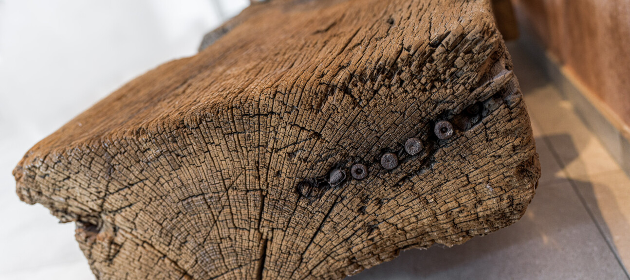 Altholz-Balken im Detail: rissiges Stirnholz mit alten Holzdübeln, sorgfältig aufbereitet von der Antikholzwerkstatt.