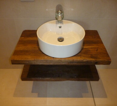 Rundes Aufsatzwaschbecken auf handgefertigtem Waschtisch aus Altholz mit unterem Ablageboden.