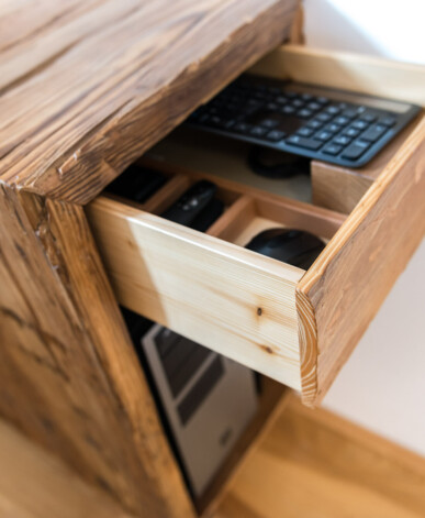 Schublade mit Tastaturfach in einem maßgefertigten Möbel aus Altholz bietet praktische Organisation für PC-Zubehör.