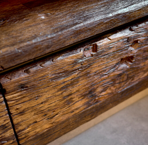 Nahaufnahme einer gebürsteten Altholzfront mit tiefer Maserung und Patina.